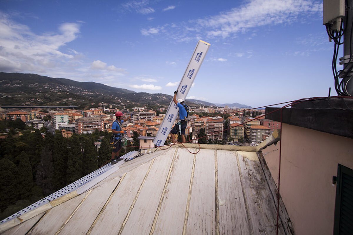 Dos trabajadores Acrobatica en el tejado dispuestos a realizar aislamiento térmico