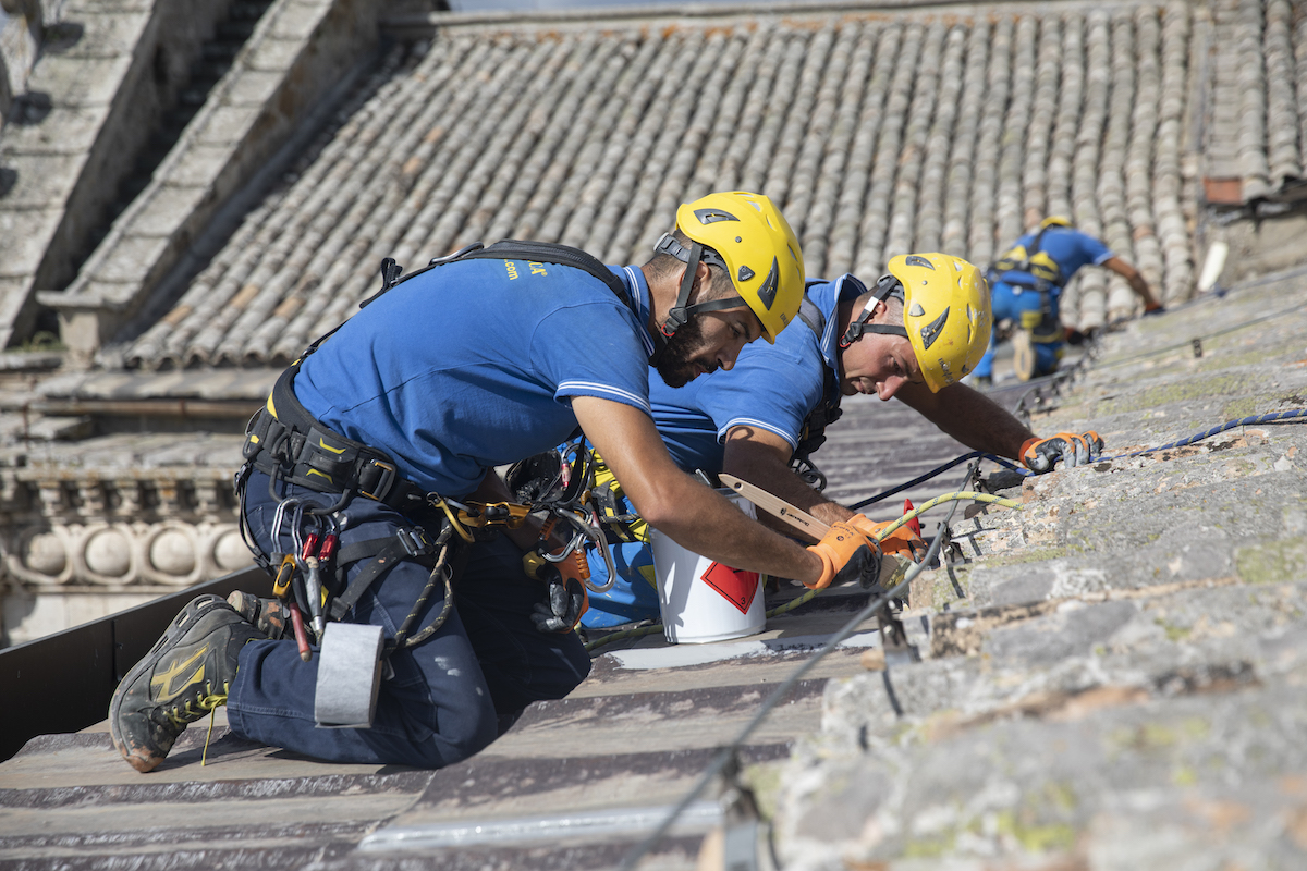 Trabajadores en el tejado durante la operación de creación de una envolvente térmica.