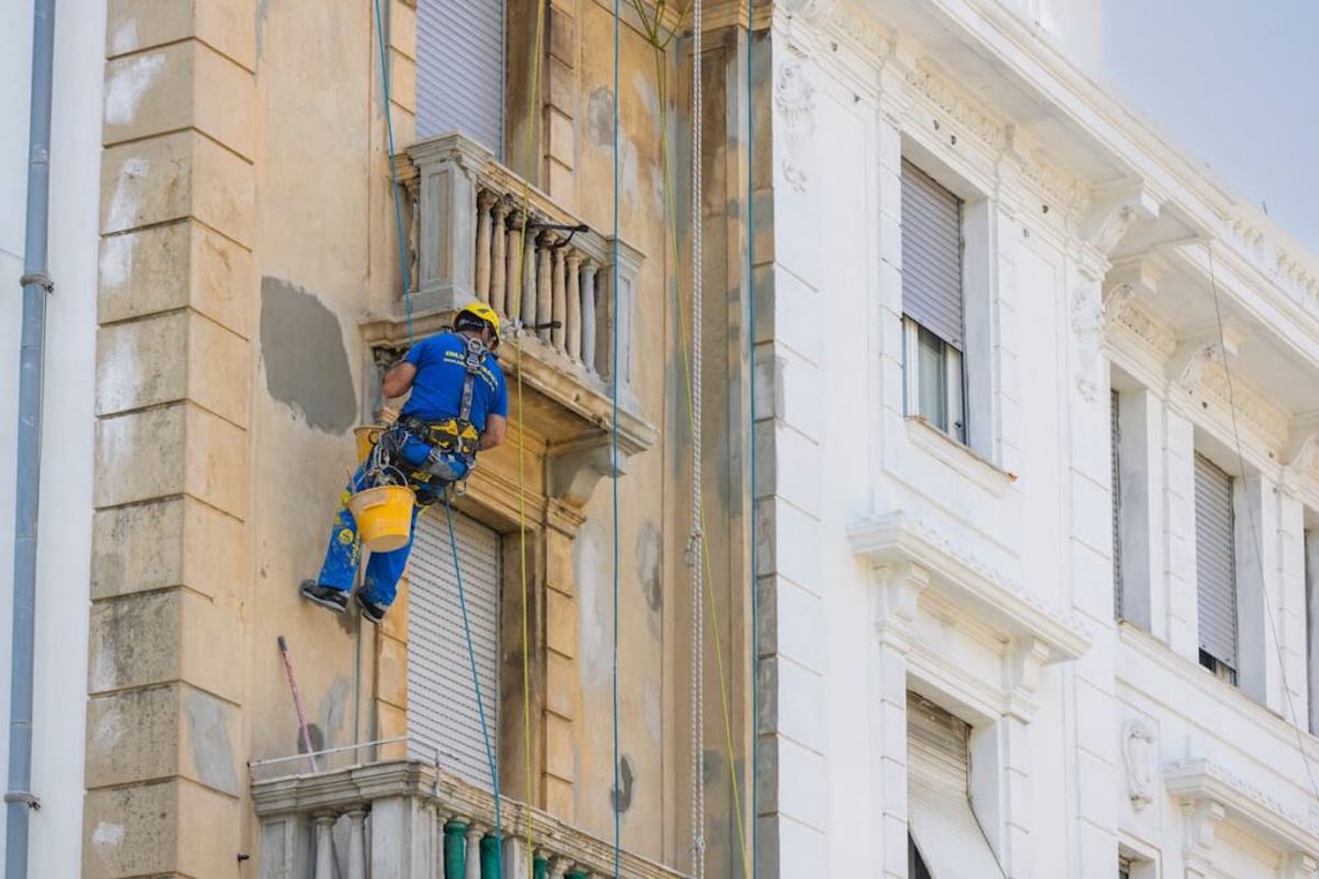 Trabajadore de Acrobatica sobre cuerdas durante la renovación de balcones