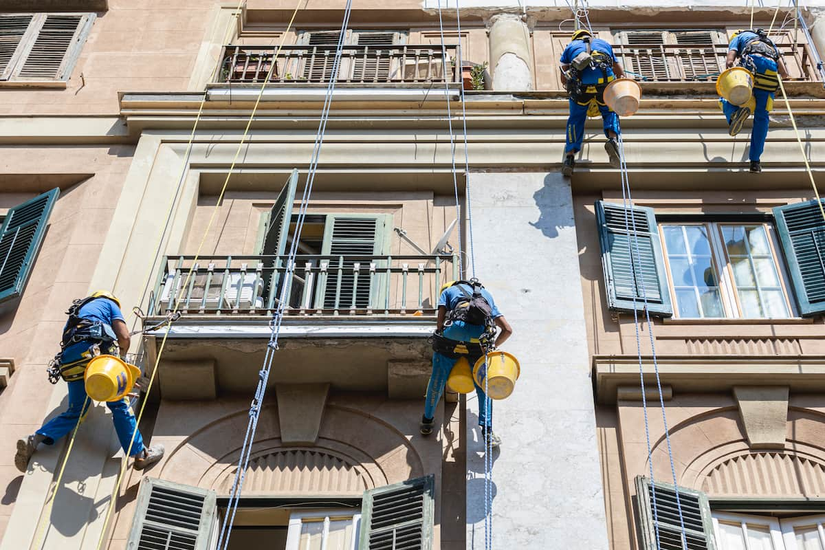 Trabajadores de Acrobatica sobre cuerdas durante la renovación de balcones