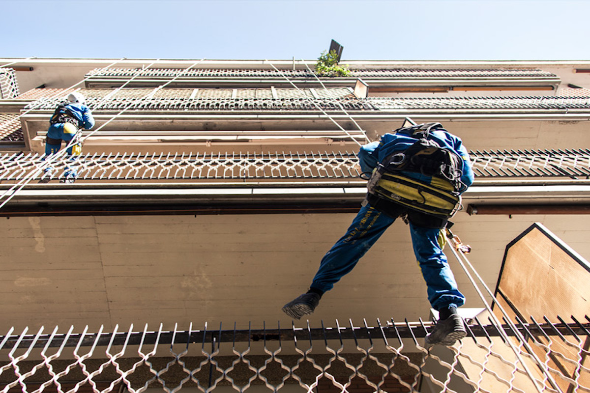 Trabajadores de Acrobatica sobre una cuerda durante los trabajos de mantenimiento en la terraza