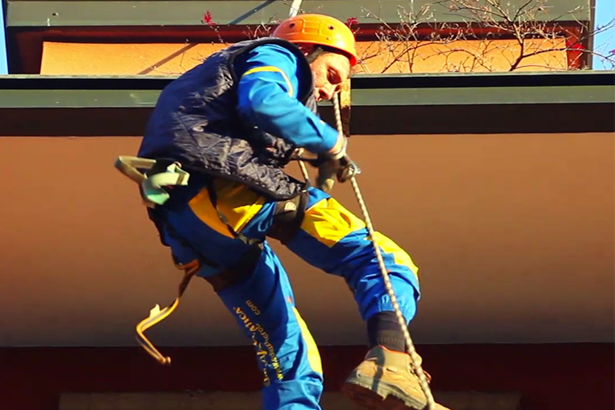 Trabajador de Acrobatica sobre una cuerda durante la impermeabilización de la terraza