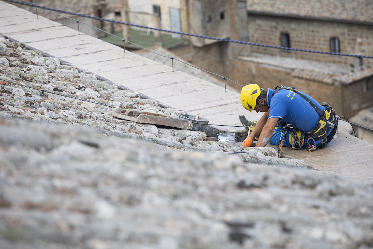 Trabajador de acrobacia mientras mantiene un techo