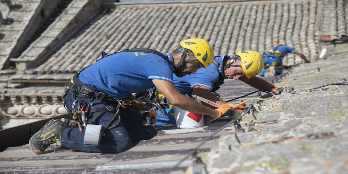 Acrobatica en el exterior de un edificio, aplicando aislamiento térmico para optimizar el rendimiento energético.