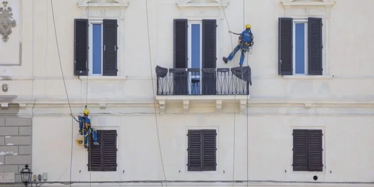 Operarios trabajando en la instalación de aislamiento en una fachada no ventilada para mejorar la eficiencia energética