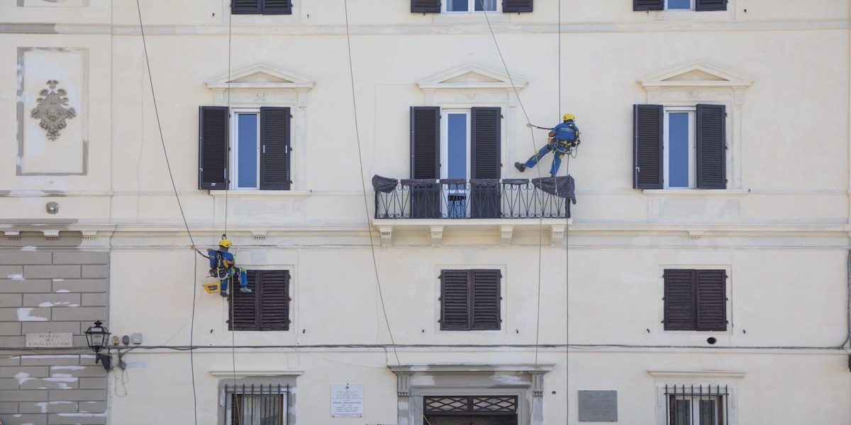 Trabajadores de acrobacia frente a una fachada ventilada