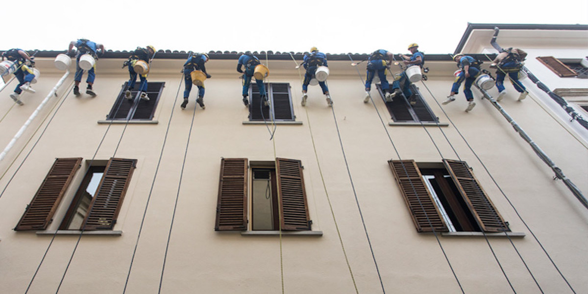 Trabajadores acrobáticos sobre una cuerda durante una operación de mantenimiento en la fachada ventilada